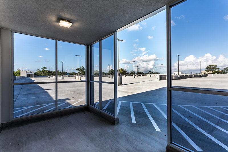 Photo through the glass windows/doors exiting out to the top floor of the parking structure.